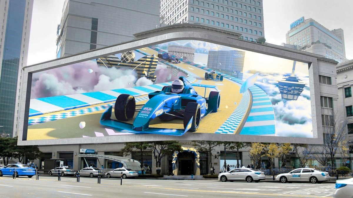 Large outdoor LED billboard displaying a race car scene on a city street